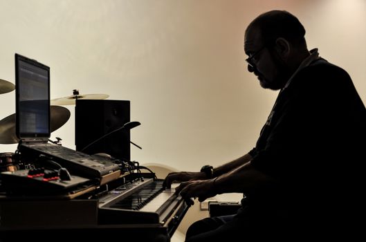 Musician playing on keyboards in a music studio 