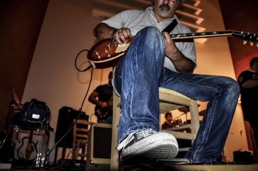 man playing electric guitar inside a music studio