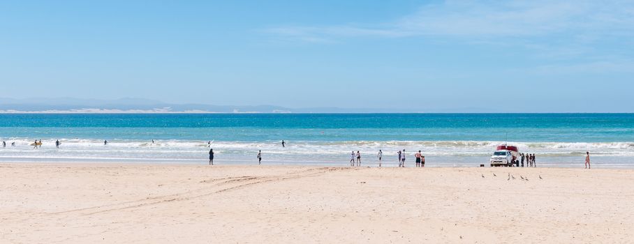 JEFFREYS BAY, SOUTH AFRICA - FEBRUARY 28, 2016:  A beach scene with a fishing boat being recovered. Unidentified people are looking on