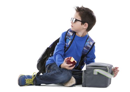 young boy student with backpack and apple in his hand on white background