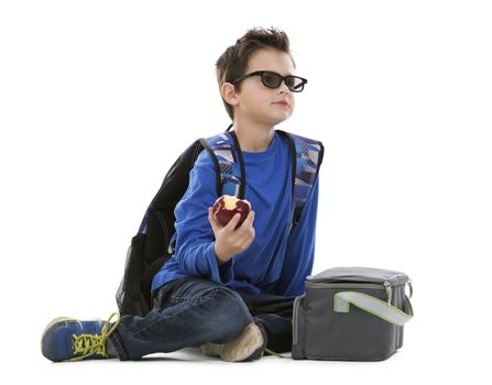 young boy student with backpack and apple in his hand on white background