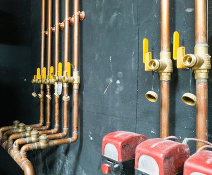 Seven copper pipes and valves mounted on the wall