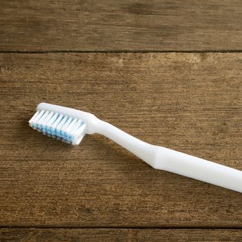 The clean white toothbrush on old wooden planks for brushing the teeth.