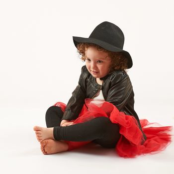 Little girl with black hat sitting and dreams