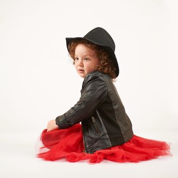 Little girl with black hat sitting and dreaming