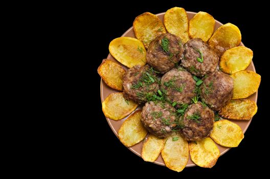 Fried meatballs with rice and fries on a plate, isolated on black background