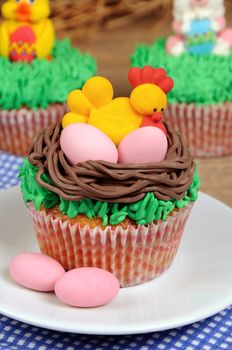 Easter Muffin decorated  hen with eggs sitting in a nest on the grass