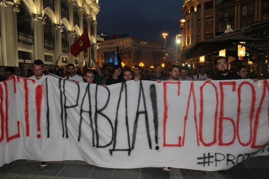 MACEDONIA, Skopje: Demonstrators march behind a banner as thousands continue anti-government protests in Skopje, Macedonia on April 19, 2016. The protests began nearly one week ago, as demonstrators denounced President Gjorge Ivanov's decision to halt probes into more than 50 public figures involved in a wiretapping scandal. Meanwhile, snap elections have been called for June 5.