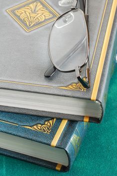 two gray and green books pile with glasses closeup