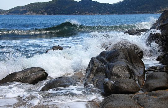 waves and stones at the blue Ionian sea seaside in Greece
