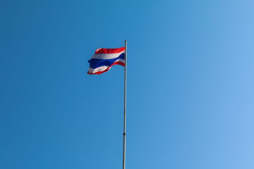 Image of waving Thai flag of Thailand with blue sky background