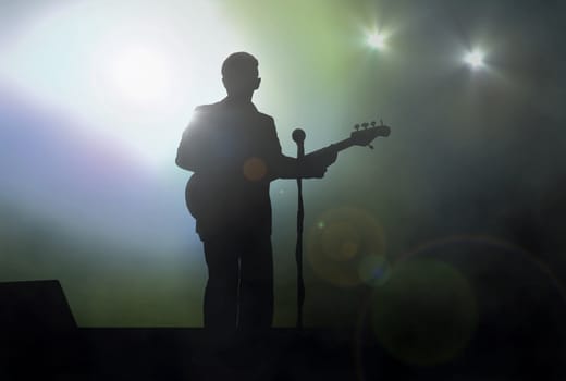 Guitarist on stage performing live under spotlight
