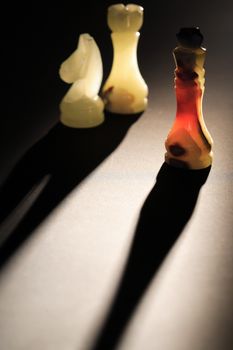 Set of chess pieces made from onyx against light on dark background