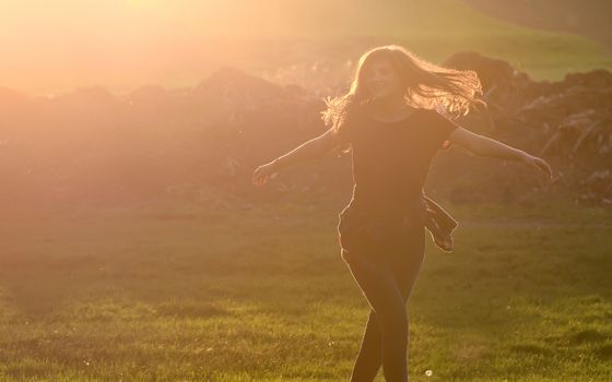 Teen girl jump against beautiful sunset in forest