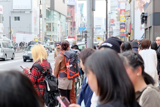Tokyo, Japan - March 30, 2016 Crowds of pedestrians crossing the busy downtown streets of Harajuku, Harajuku is known as a center of Japanese youth culture and fashion.
