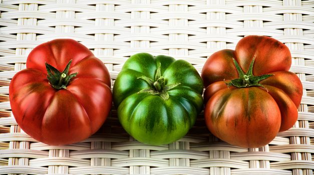 Red, Green and Orange Raw Ripe Tomatoes with Stems closeup on White Wicker background. Sort Fields Raf 