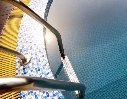 Grab bars ladder in blue swimming pool