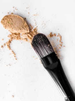 scattered beige eye shadow on a white background