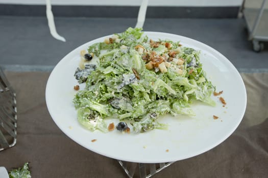 A plated caesar salad on buffet.