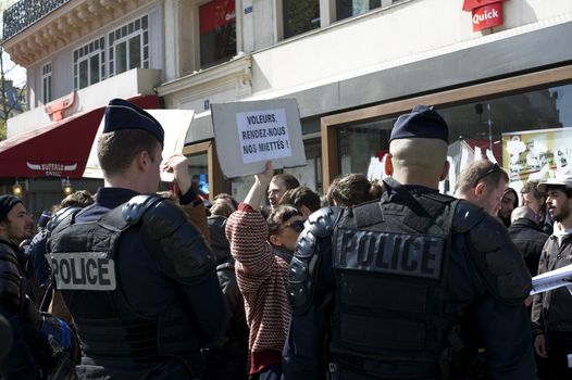 FRANCE, Paris : Demonstrators part of the Nuit Debout movement face police officers during a protest against split shifts and to demand wage increases in front of a fast food restaurant in Paris on April 20, 2016. 
