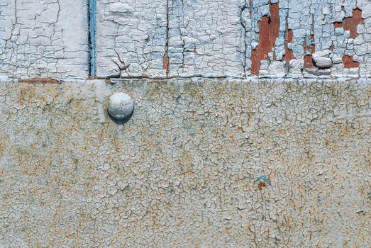 the door of planks covered with sheets of rusty metal, chipped old paint, which has long been under the influence of various climatic conditions