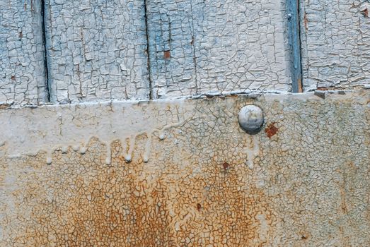 the door of planks covered with sheets of rusty metal, chipped old paint, which has long been under the influence of various climatic conditions