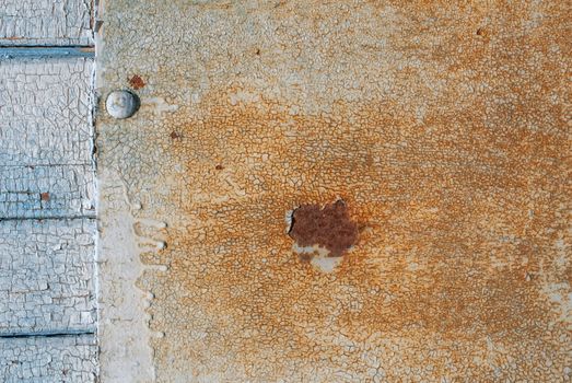 the door of planks covered with sheets of rusty metal, chipped old paint, which has long been under the influence of various climatic conditions