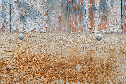 the door of planks covered with sheets of rusty metal, chipped old paint, which has long been under the influence of various climatic conditions