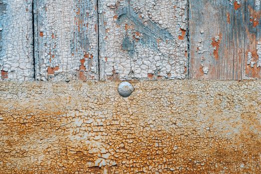 the door of planks covered with sheets of rusty metal, chipped old paint, which has long been under the influence of various climatic conditions