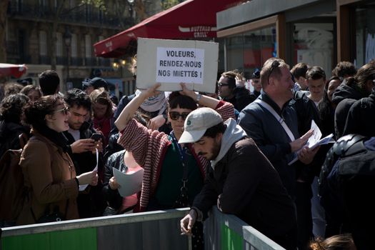 FRANCE, Paris : Demonstrators part of the Nuit Debout movement face police officers during a protest against split shifts and to demand wage increases in front of a fast food restaurant in Paris on April 20, 2016. 