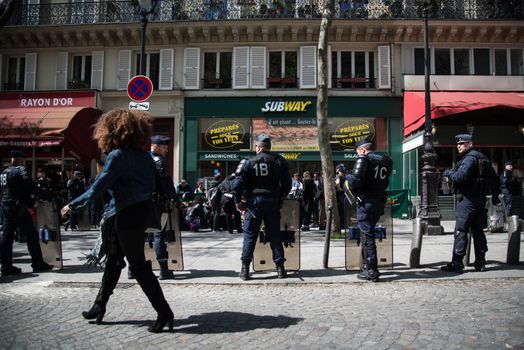 FRANCE, Paris : Demonstrators part of the Nuit Debout movement face police officers during a protest against split shifts and to demand wage increases in front of a fast food restaurant in Paris on April 20, 2016.