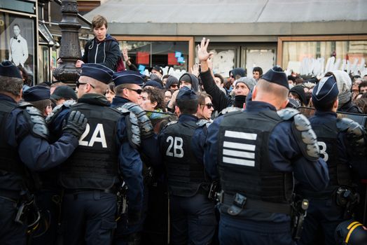 FRANCE, Paris : Demonstrators part of the Nuit Debout movement face police officers during a protest against split shifts and to demand wage increases in front of a fast food restaurant in Paris on April 20, 2016.