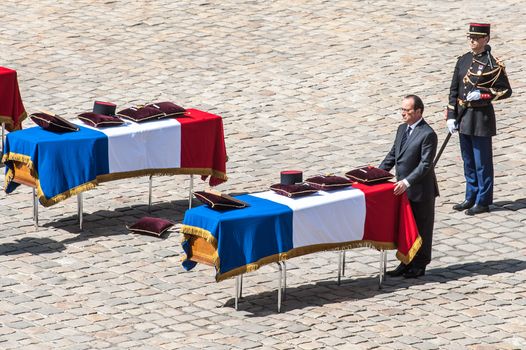 FRANCE, Paris : French President Francois Hollande pays his respect as he stands in front of one of the three coffins with the bodies of three French soldiers killed in service in Mali last week, during a solemn and national tribute ceremony at the Hotel des Invalides in Paris, on April 20, 2016.Three French peacekeeping soldiers died after their armoured car ran over a landmine in Mali, the French presidency said April 13, 2016. One soldier, Mickael Poo-Sing, was killed immediately in the blast on April 12, 2016 and President Francois Hollande learned with great sadness that two more soldiers had died in the west African country, a statement said. The car was leading a convoy of around 60 vehicles travelling to the northern desert town of Tessalit when it hit the mine, according to the French defence ministry. The troops were part of Operation Barkhane, under which France has some 3,500 soldiers deployed across five countries in the Sahel region, south of the Sahara desert, to combat the jihadist insurgency raging there.