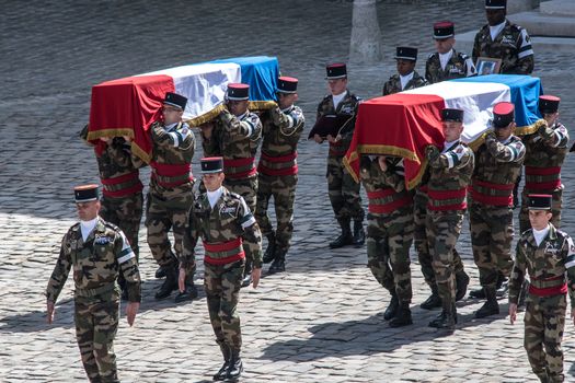 FRANCE, Paris : Soldiers carry the three coffins drapped with the French national flag with the bodies of three French soldiers killed in service in Mali last week, during a solemn and national tribute ceremony at the Hotel des Invalides in Paris, on April 20, 2016.Three French peacekeeping soldiers died after their armoured car ran over a landmine in Mali, the French presidency said April 13, 2016. One soldier, Mickael Poo-Sing, was killed immediately in the blast on April 12, 2016 and President Francois Hollande learned with great sadness that two more soldiers had died in the west African country, a statement said. The car was leading a convoy of around 60 vehicles travelling to the northern desert town of Tessalit when it hit the mine, according to the French defence ministry. The troops were part of Operation Barkhane, under which France has some 3,500 soldiers deployed across five countries in the Sahel region, south of the Sahara desert, to combat the jihadist insurgency raging there.