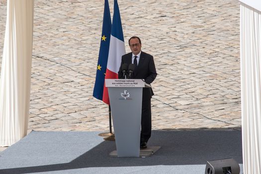 FRANCE, Paris : French President Francois Hollande pays his respect as he delivers a speech, during a solemn and national tribute ceremony at the Hotel des Invalides in Paris, on April 20, 2016.Three French peacekeeping soldiers died after their armoured car ran over a landmine in Mali, the French presidency said April 13, 2016. One soldier, Mickael Poo-Sing, was killed immediately in the blast on April 12, 2016 and President Francois Hollande learned with great sadness that two more soldiers had died in the west African country, a statement said. The car was leading a convoy of around 60 vehicles travelling to the northern desert town of Tessalit when it hit the mine, according to the French defence ministry. The troops were part of Operation Barkhane, under which France has some 3,500 soldiers deployed across five countries in the Sahel region, south of the Sahara desert, to combat the jihadist insurgency raging there.