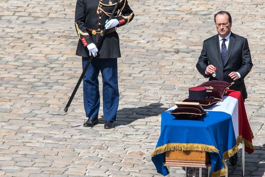 FRANCE, Paris : French President Francois Hollande pays his respect as he stands in front of one of the three coffins with the bodies of three French soldiers killed in service in Mali last week, during a solemn and national tribute ceremony at the Hotel des Invalides in Paris, on April 20, 2016.Three French peacekeeping soldiers died after their armoured car ran over a landmine in Mali, the French presidency said April 13, 2016. One soldier, Mickael Poo-Sing, was killed immediately in the blast on April 12, 2016 and President Francois Hollande learned with great sadness that two more soldiers had died in the west African country, a statement said. The car was leading a convoy of around 60 vehicles travelling to the northern desert town of Tessalit when it hit the mine, according to the French defence ministry. The troops were part of Operation Barkhane, under which France has some 3,500 soldiers deployed across five countries in the Sahel region, south of the Sahara desert, to combat the jihadist insurgency raging there. 