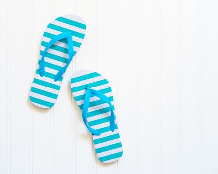 Blue and white beach sandals commonly call flip flops.