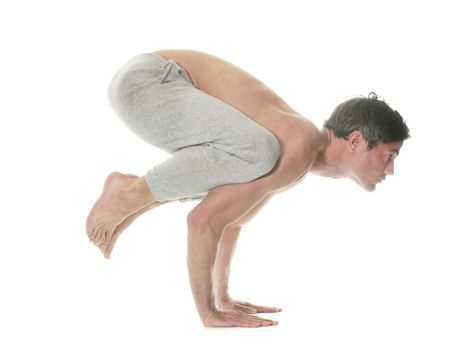 man doing yoga in front of white background