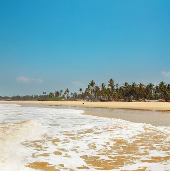 Kolva, India - April 20, 2016: Goan beach panorama with sea, fisherman boats and palms