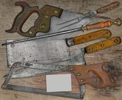 vintage butcher shop tools over stained wooden table,space on business card for your text