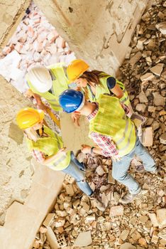 Four construction architects review plan in building damaged in the disaster.