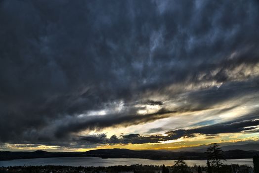 Sunset and storm clouds over the Lake of Varese in an autumn afternoon