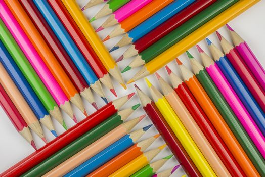 Abstract composition of a set wooden colour pencils against a white background
