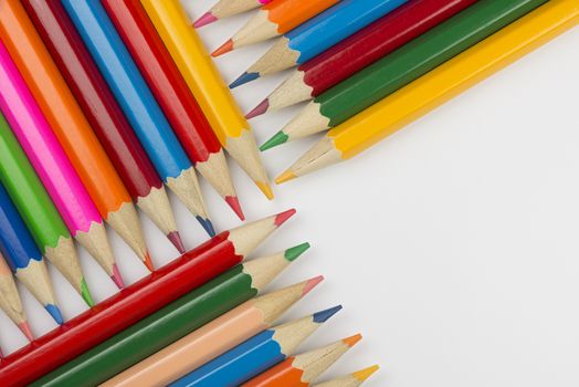 Abstract composition of a set wooden colour pencils against a white background
