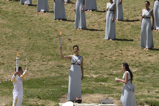 GREECE, Olympia: An actress performing as the priestess holds a pot with the Olympic flame at the Temple of Hera on April 21, 2016, during the lighting ceremony of the Olympic flame in ancient Olympia, the sanctuary where the Olympic Games were born in 776 BC. The Olympic flame was lit  in an ancient temple in one country in crisis and solemnly sent off carrying international hopes that Brazil's political paralysis will not taint the Rio Games that start in barely 100 days. 
