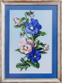 Heaps of beads lying on the canvas, embroidered pattern and frame