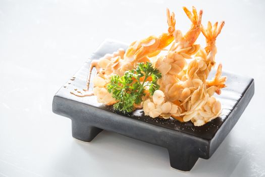 deep fried almond shrimp tempura on black plate