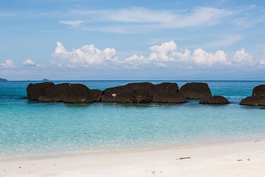 white sand blue sea and stone on beautiful beach