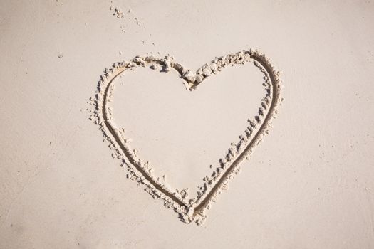 drawing heart symbol on the beach show romantic feeling