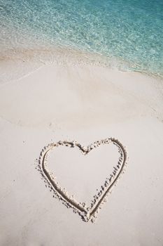 drawing heart symbol on the beach show romantic feeling